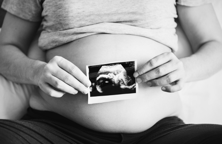 a pregnant woman sitting on the couch